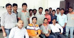 roup photo of office employees and staff members posing together indoors.